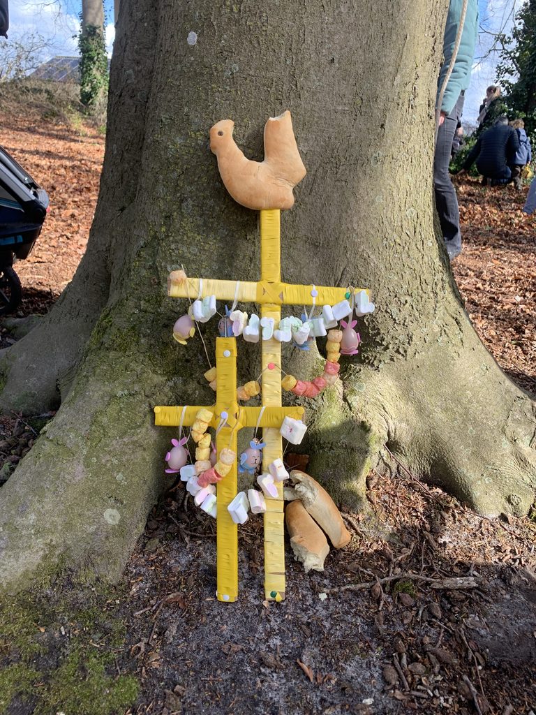 Een versierde palmpaasstok tegen een boom